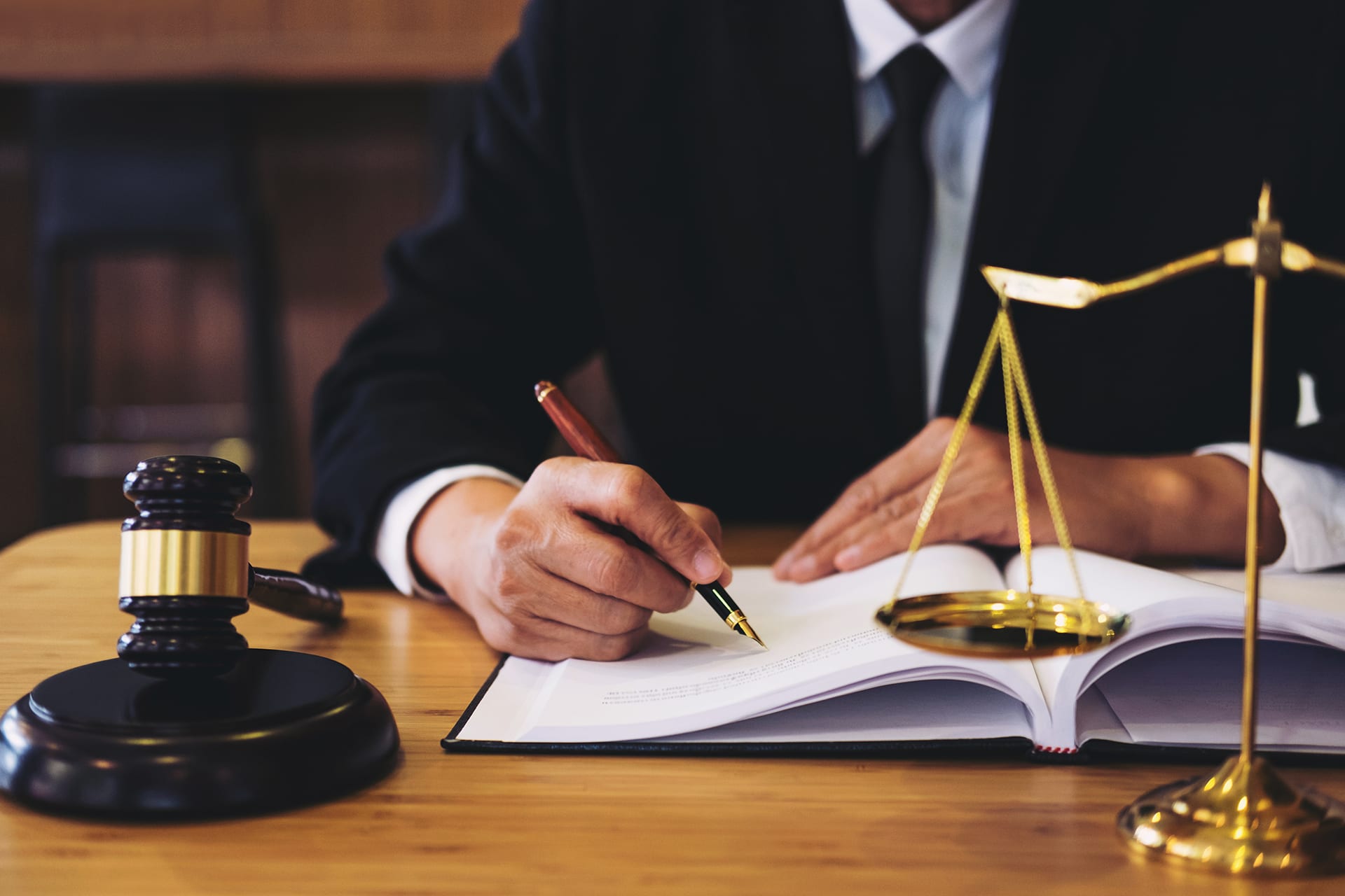 Lawyer working on paper with symbols of justice on table